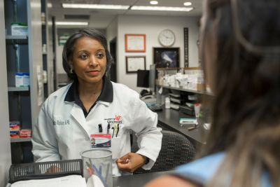 woman in a lab coat speaking with a patient
