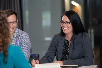 woman speaking with two other people at a table