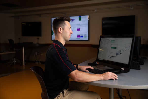 man sitting and working in front of a laptop