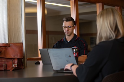 two students sitting in front of a computer