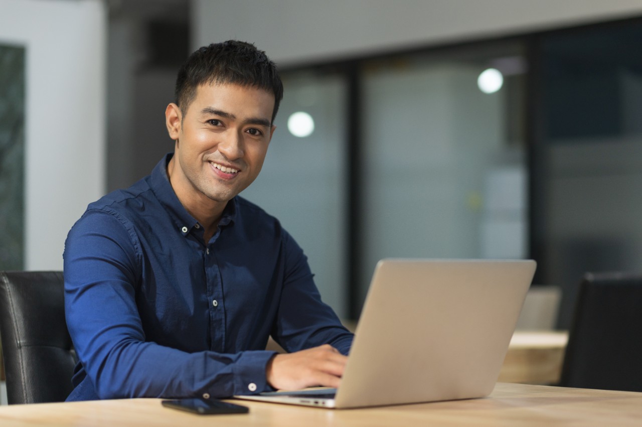 Young asian businessman working with laptop in office.